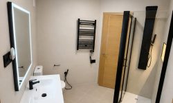 Reforma de baño moderno, minimalista, con detalles negros y plato de ducha