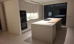cocina minimalista y moderna con isla de piedra gris central