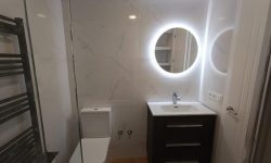 reforma de baño pequeño y moderno con espejo redondo con luz