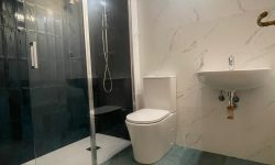 baño moderno con plato de ducha y azulejos blancos