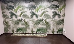 Local comercial reformado con pared decorada con papel pintado tropical.