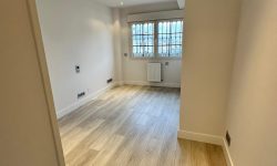 habitación pequeña reformada con suelo cambiado y ventana trasera