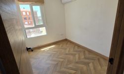 Habitación reformada con suelo tipo parqué en espiga, e instalación de aire acondicionado.