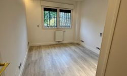 habitación con parqué de madera y ventana luminosa