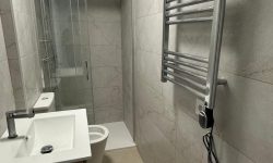 Baño alargado acabo en piedra, moderno