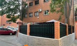Muro de ladrillo gris y valla verde
